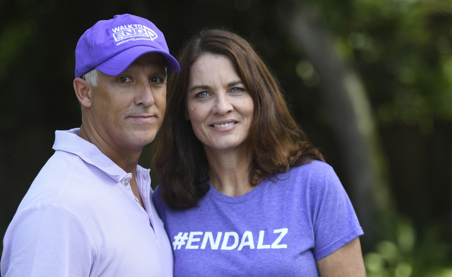Michele Hall stands with her husband, Doug, in their backyard Thursday in Bradenton, Fla. Hall, 54, diagnosed with early Alzheimer's last year, calls the new drug Aduhelm "the first tiny glimmer of hope" she'll get more quality time with her husband and their three adult children.