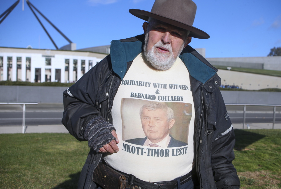 Demonstrator Dierk von Behrens protests outside Parliament House in Canberra, Australia, Thursday, June 17, 2021 against the prosecution of lawyer Bernard Collaery whose picture is on the demonstrator's shirt. Critics of the secret prosecutions of a former Australian spy and his lawyer argue they are another example of a government concealing political embarrassment under the guise of national security.