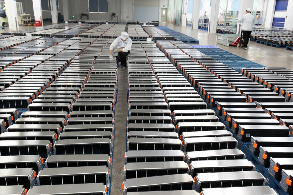 This photo taken on March 12, 2021 shows a worker with car batteries in a factory for Xinwangda Electric Vehicle Battery Co. Ltd in Nanjing, China. China is home to more than 75% of all battery production capacity and around 80% of global refining capacity for EV minerals, giving it immense influence over the battery supply chain.