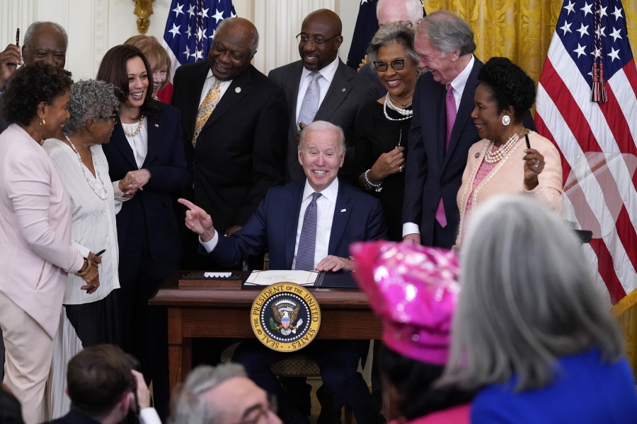 President Joe Biden points to Opal Lee after signing the Juneteenth National Independence Day Act, in the East Room of the White House, Thursday, June 17, 2021, in Washington. From left, Rep. Barbara Lee, D-Calif, Rep. Danny Davis, D-Ill., Opal Lee, Sen. Tina Smith, D-Minn., Vice President Kamala Harris, House Majority Whip James Clyburn of S.C., Sen. Raphael Warnock, D-Ga., Sen. John Cornyn, R-Texas, obscured, Rep. Joyce Beatty, D-Ohio, Sen. Ed Markey, D-Mass., and Rep. Sheila Jackson Lee, D-Texas.