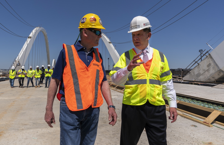 FILE - In this May 19, 2021, file photo Secretary of Labor Marty Walsh, right, visits the Frederick Douglass Memorial Bridge construction site together with District of Columbia Mayor Muriel Bowser and Secretary of Transportation Pete Buttigieg, in southeast Washington.