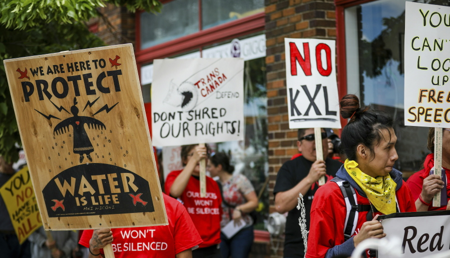 FILE - In this Jun 12, 2019, file photo, walking up Main Street the procession protesting against the Keystone XL pipeline makes its way to Andrew W. Bogue Federal Courthouse in Rapid City, S.D.