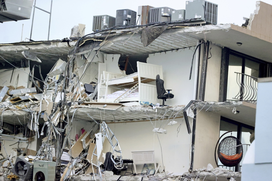 Debris dangles from Champlain Towers South Condo after the multistory building partially collapsed Thursday, June 24, 2021, in Surfside, Fla.