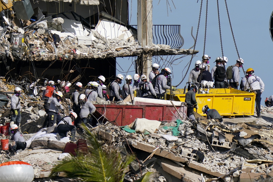 FILE - In this June 28, 2021, file photo, workers search the rubble at the Champlain Towers South Condo in Surfside, Fla. Search and rescue teams from Miami-Dade have been described as among the best and most experienced in the world.