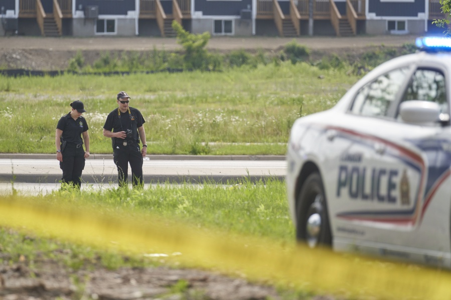 London Police investigate the scene of a car crash in London, Ontario on Monday, June 7, 2021. Police say multiple people have died after several pedestrians were struck by a car Sunday night.