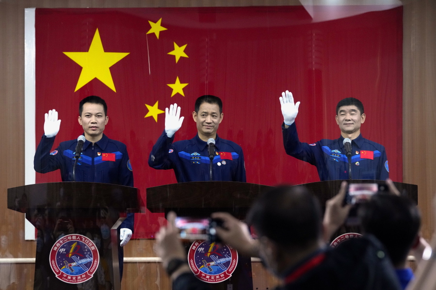 Chinese astronauts, from left, Tang Hongbo, Nie Haisheng, and Liu Boming wave at a press conference at the Jiuquan Satellite Launch Center ahead of the Shenzhou-12 launch from Jiuquan in northwestern China, Wednesday, June 16, 2021. China plans on Thursday to launch three astronauts onboard the Shenzhou-12 spaceship, who will be the first crew members to live on China's new orbiting space station Tianhe, or Heavenly Harmony from the Jiuquan Satellite Launch Center in northwest China.