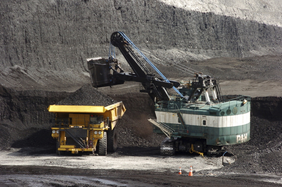 FILE - In this April 4, 2013, file photo, a mechanized shovel loads a haul truck with coal at the Spring Creek coal mine near Decker, Mont. A judge says U.S officials downplayed the climate change impacts and other environmental costs from the expansion of a massive coal mine near the Montana-Wyoming border, in a case that could show how far the Biden administration is willing to go to unwind his predecessors' decisions.