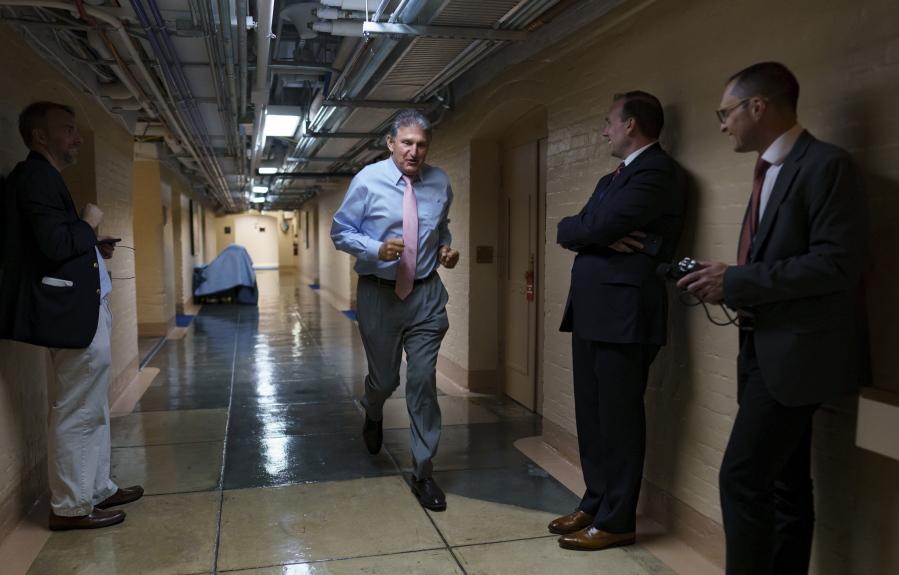 Sen. Joe Manchin, D-W.Va., one of the key Senate infrastructure negotiators, rushes back to a basement room at the Capitol as he and other Democrats work behind closed doors, in Washington, Wednesday, June 16, 2021. (AP Photo/J.
