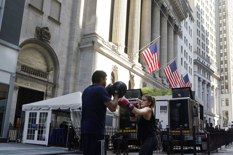 A woman and her trainer workout outside the New York Stock Exchange, Monday, June 7, 2021. Stocks are opening higher on Wall Street Thursday, June 10 nudging the S&P 500 back into the green for the week. The benchmark index was up 0.6 percent in the early going, and the tech-heavy Nasdaq was up 0.4 percent.