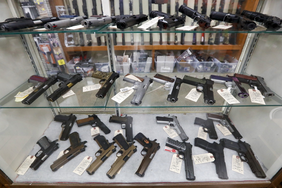 FILE - In this March 25, 2020, file photo semi-automatic handguns are displayed at shop in New Castle, Pa. The number of people stopped from buying guns though the U.S. background check system hit an all-time high of more than 300,000 last year amid a surge of firearm sales, according to new records obtained by the group Everytown for Gun Safety.  The FBI numbers provided to The Associated Press show the background checks blocked nearly twice as many gun sales in 2020 as in the year before.