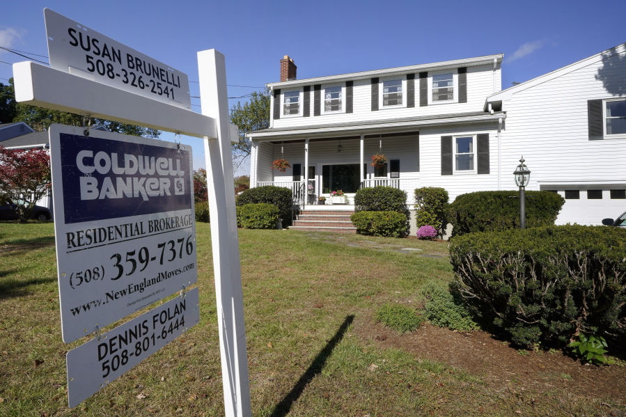 FILE - In this Oct. 6, 2020 file photo, a real estate brokerage sign stands in front of a house in Norwood, Mass. Sales of previously-occupied homes fell for the fourth straight month in May 2021, as soaring prices and a limited number of available properties discouraged many would-be buyers.