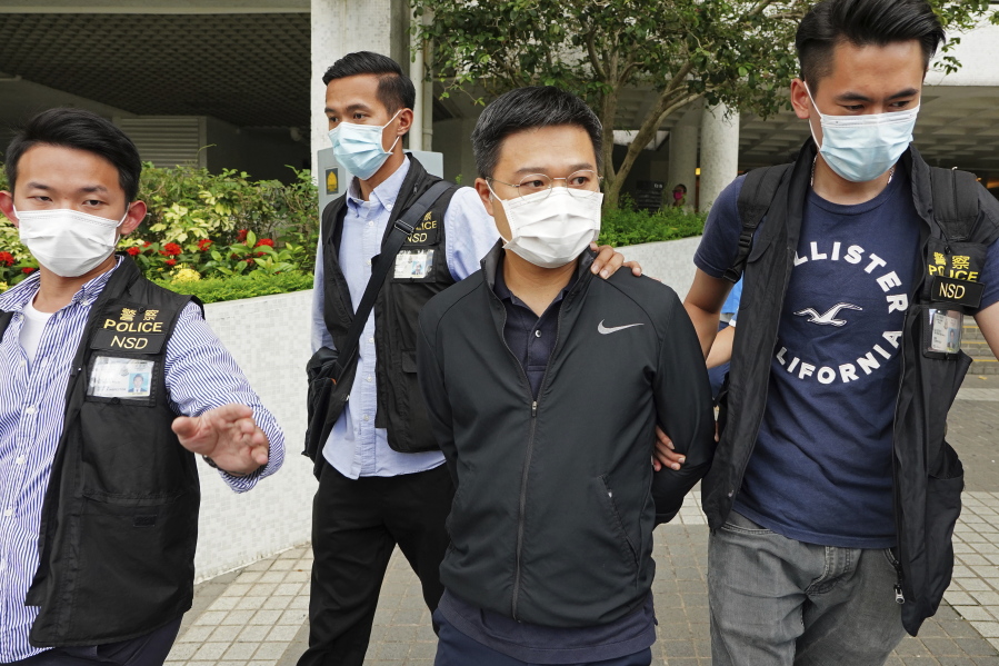 Ryan Law, second from right, Apple Daily's chief editor, is arrested by police officers in Hong Kong Thursday, June 17, 2021. Hong Kong police on Thursday morning arrested the chief editor and four other senior executives of Apple Daily under the national security law on suspicion of collusion with a foreign country to endanger national security, according to local media reports. Local media, including the South China Morning Post and Apple Daily, reported Thursday that national security police arrested Apple Daily's chief editor Ryan Law.