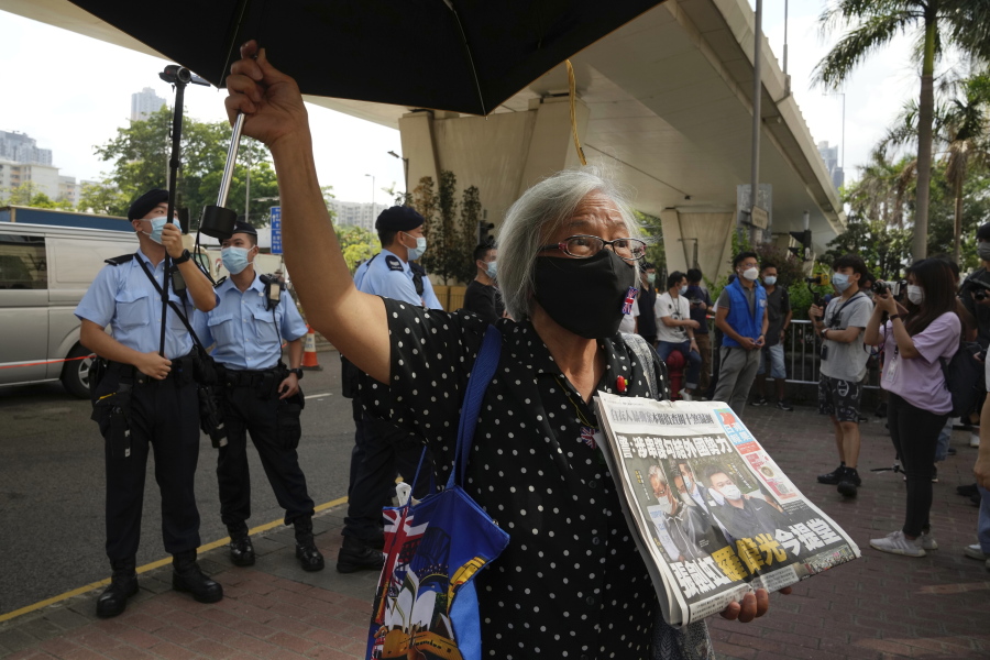 A pro-democracy activist holding a copy of Apple Daily newspaper protests outside a court in Hong Kong, Saturday, June 19, 2021, to demand to release political prisoners.