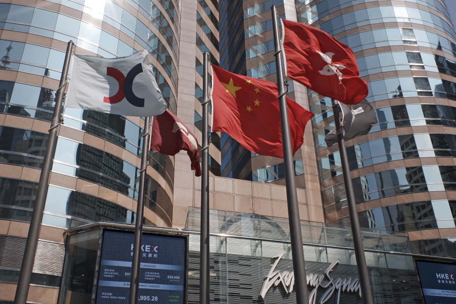 FILE - In this Oct. 9, 2019, file photo, flags are raised outside the Hong Kong Exchange Square building in Central of Hong Kong. The Hong Kong Stock Exchange said it was hit by technical problems Thursday as a wave of brief internet outages appeared to hit dozens of financial institutions, airlines and other companies across the globe.