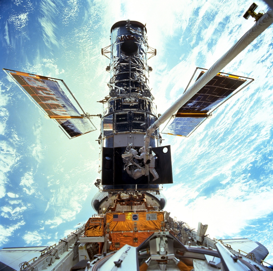 FILE - In this image provided by NASA/JSC, astronauts Steven L. Smith and John M. Grunsfeld are photographed during an extravehicular activity (EVA) during the December 1999 Hubble servicing mission of STS-103, flown by Discovery. The Hubble Space Telescope has been blindsided by computer trouble, with all astronomical viewing halted, NASA said Wednesday, June 16, 2021. The orbiting observatory has been idle since Sunday when a 1980s-era computer that controls the science instruments shut down, possibly because of a bad memory board.