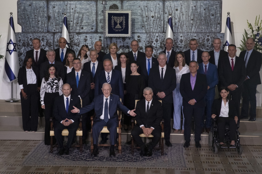 Israeli Prime Minister Naftali Bennett, seated left, President Reuven Rivlin, seated center, and Alternate Prime Minister and Minister of Foreign Affairs Yair Lapid seated right, pose for a group photo with the ministers of the new government at the President's residence in Jerusalem, Monday, June 14, 2021.