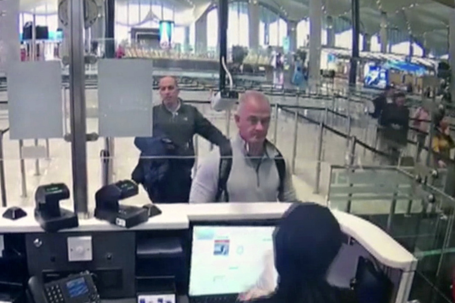 FILE-- This Dec. 30, 2019 image from security camera video shows Michael L. Taylor, center, and George-Antoine Zayek at passport control at Istanbul Airport in Turkey. Americans Michael Taylor and his son Peter Taylor go on trial in Tokyo on Monday, June 14, 2021, on suspicion they helped Nissan former Chairman Carlos Ghosn skip bail in Japan and escape to Lebanon in December 2019.