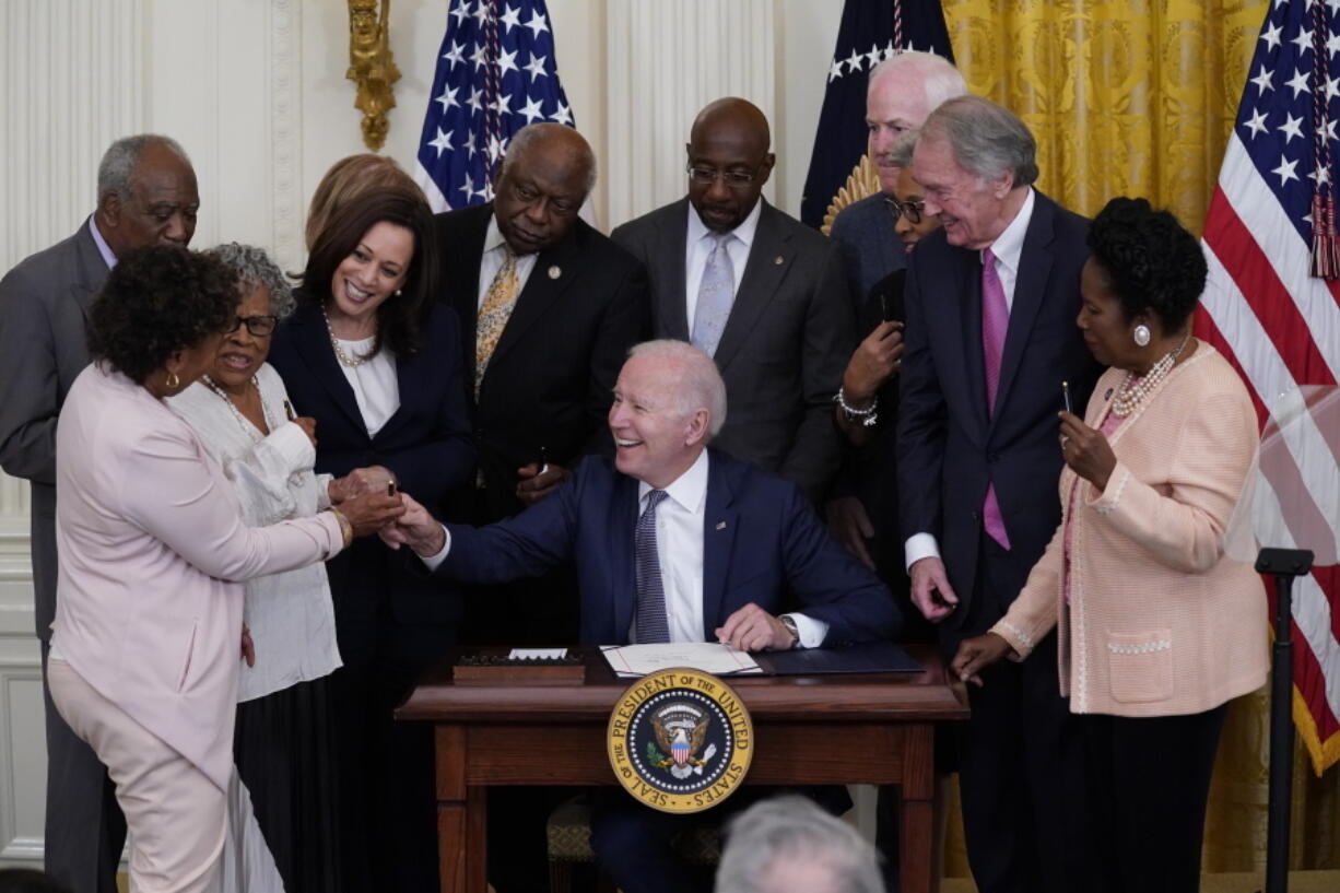 FILE - In this June 17, 2021, file photo, President Joe Biden hands a pen to Rep. Barbara Lee, D-Calif., after signing the Juneteenth National Independence Day Act, in the East Room of the White House in Washington. From left, Rep. Barbara Lee, D-Calif, Rep. Danny Davis, D-Ill., Opal Lee, Sen. Tina Smith, D-Minn., obscured, Vice President Kamala Harris, House Majority Whip James Clyburn of S.C., Sen. Raphael Warnock, D-Ga., Sen. John Cornyn, R-Texas, Rep. Joyce Beatty, D-Ohio, obscured, Sen. Ed Markey, D-Mass., and Rep. Sheila Jackson Lee, D-Texas.