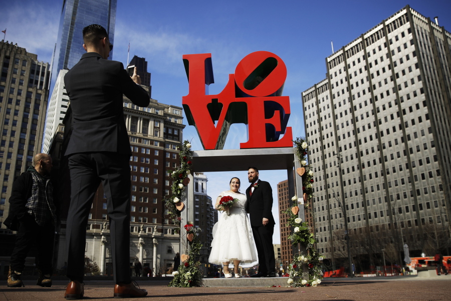 Newlyweds Jennifer and Paul Raffa pose Feb. 14, 2019, for a photograph under the Robert Indiana "LOVE" sculpture at John F. Kennedy Plaza in Philadelphia on Valentine's Day.