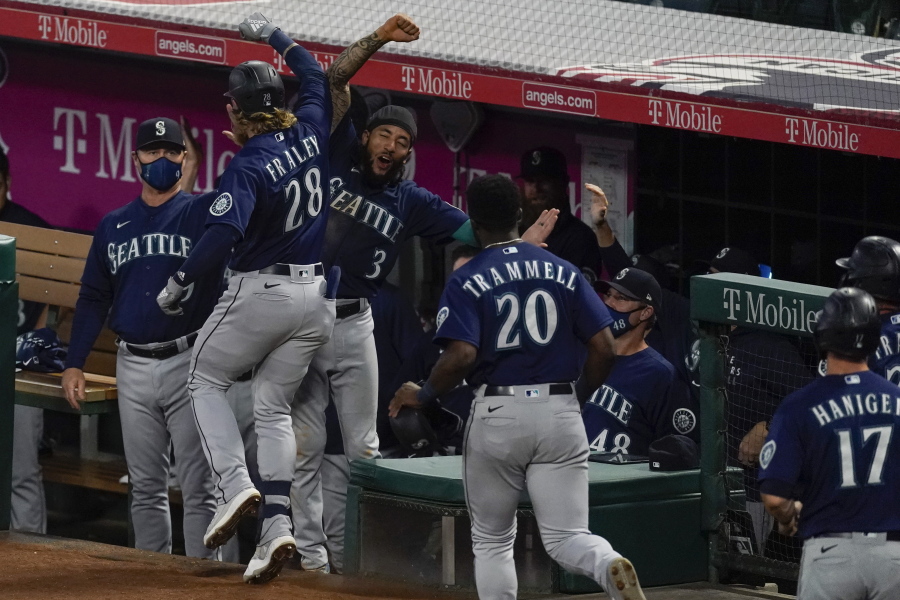 Seattle Mariners designated hitter Jake Fraley (28) celebrates with J.P. Crawford (3) after hitting a grand slam home run during the fourth inning of a baseball game against the Los Angeles Angels Saturday, June 5, 2021, in Anaheim, Calif. Mitch Haniger, Ty France, and Taylor Trammell also scored.
