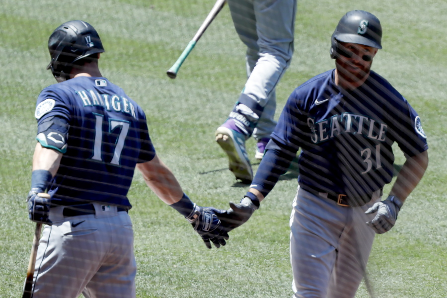 Seattle Mariners' Donovan Walton, right, gets congratulations from Mitch Haniger, after Walton hits a solo home run against the Los Angeles Angels during the third inning of a baseball game in Anaheim, Calif., Sunday, June 6, 2021.