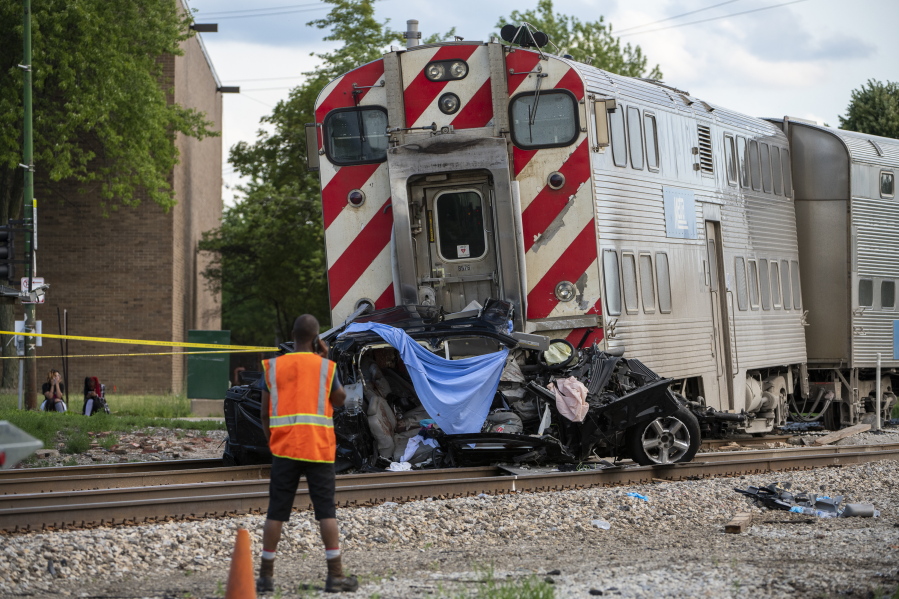 Metra police and engineers work the scene where a train collided with a vehicle, killing three occupants, including a child, in the 10300 block of South Vincennes in the East Beverly neighborhood of Chicago, Sunday, June 27, 2021.