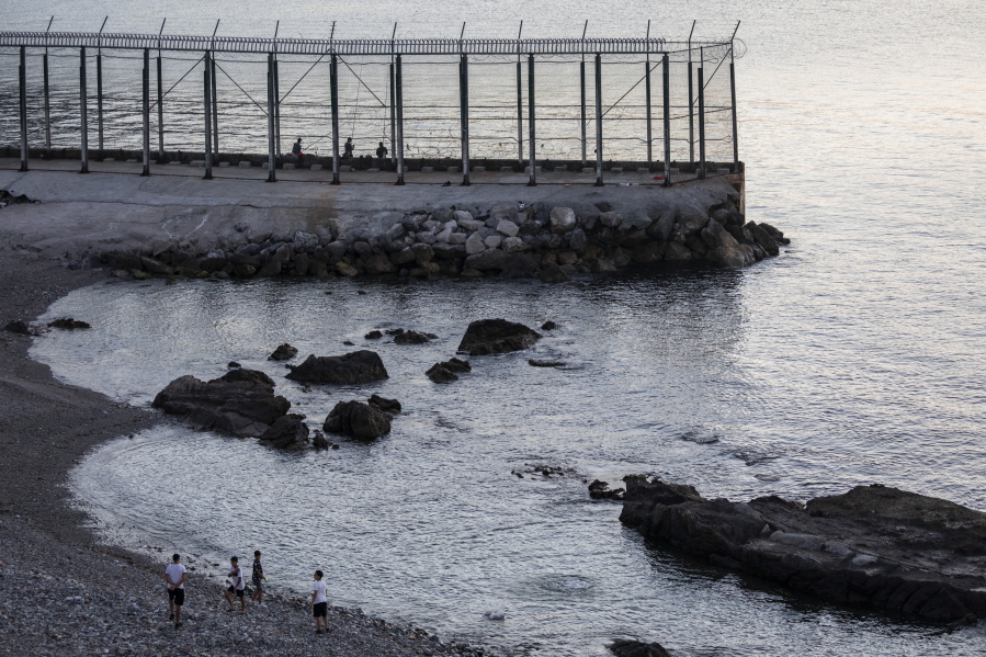 Spanish children play on the beach June 3 near the border fence separating Morocco and the  Spanish enclave of Ceuta.
