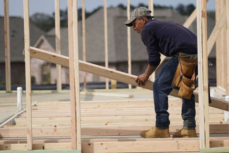 A carpenter aligns a beam for a wall frame at a new house site in Madison County, Miss., Tuesday, March 16, 2021.  U.S. home construction fell by a bigger-than-expected amount in April but the drop came after housing had risen to the highest level in 15 years. The Commerce Department said Tuesday, May 18, that construction dropped 9.5% in April to a seasonally adjusted annual rate of 1.57 million units.  % in April to an annual rate of 1.76 million units, a good sign that the April dip in construction will be temporary.  (AP Photo/Rogelio V.