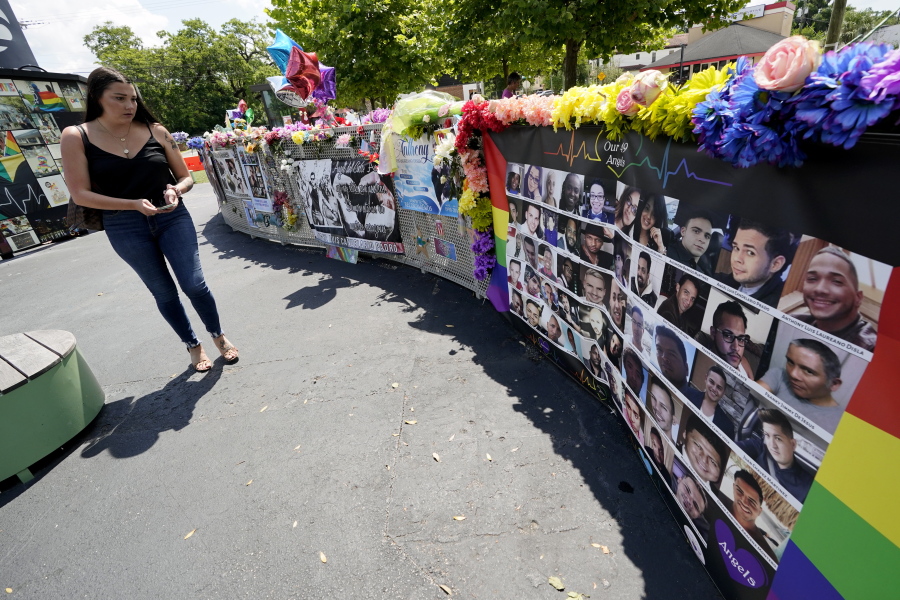 A visitor looks over a display with the photos and names of the 49 victims that died at the Pulse nightclub memorial Friday, June 11, 2021, in Orlando, Fla. Saturday will mark the fifth anniversary of the mass shooting at the site.
