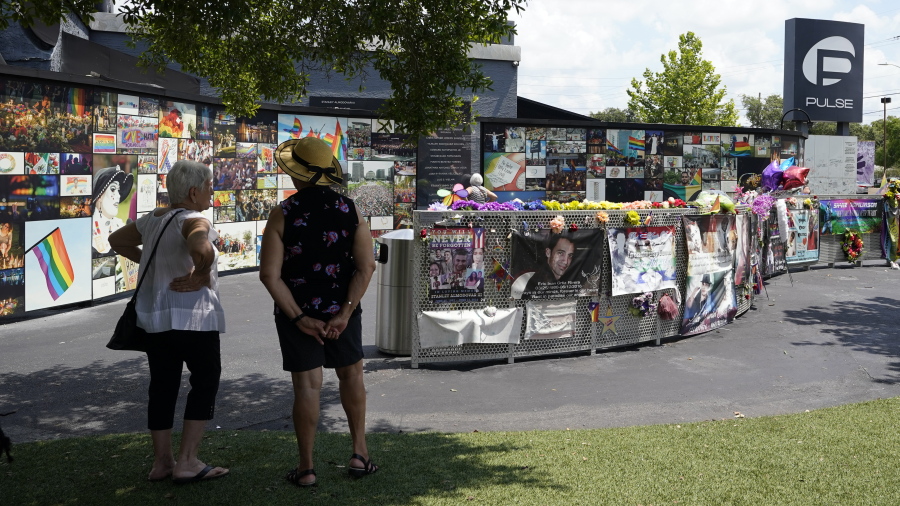 Visitors pay tribute to the display outside the Pulse nightclub memorial Friday, June 11, 2021, in Orlando, Fla. Saturday will mark the fifth anniversary of the mass shooting at the site.