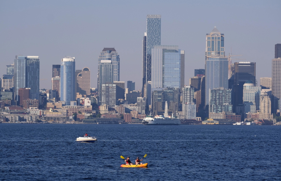 Kayakers and boaters ply the waters of Elliott Bay with the Seattle skyline behind during a heat wave hitting the Pacific Northwest, Sunday, June 27, 2021. The day before set a record high for the day with more record highs expected today and Monday.