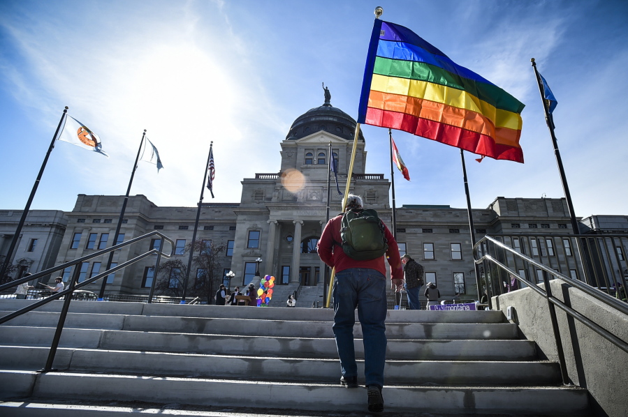 FILE - In this March 15, 2021, file photo, demonstrators gather on the steps of the Montana State Capitol protesting anti-LGBTQ+ legislation in Helena, Mont. Gov. Greg Gianforte signed a bill Friday, May 7, 2021, banning transgender athletes from participating in school and university sports according to the gender with which they identify, making Montana one of several Republican-controlled states to approve such measures in 2021.