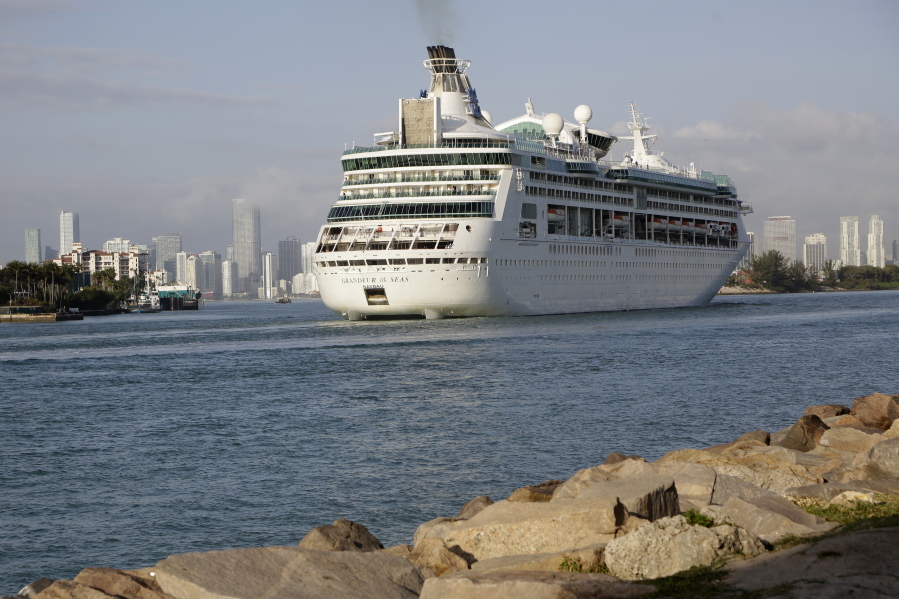 FILE - In this Monday, Feb. 5, 2018 file photo, Royal Caribbean's Grandeur of the Seas comes into the Port of Miami in Miami Beach, Fla. Royal Caribbean International said Friday, June 4, 2021 that eight of its ships will resume U.S. voyages in July and August with trips leaving ports in Florida, Texas and Washington state.  The cruise line said all crew members will be vaccinated against COVID-19.