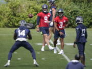 Seattle Seahawks quarterback Russell Wilson (3) passes to wide receiver DK Metcalf (14) during NFL football practice Tuesday, June 8, 2021, in Renton, as quarterback Danny Etling (9) and wide receiver Darvin Kidsy (23) look on. (AP Photo/Ted S.