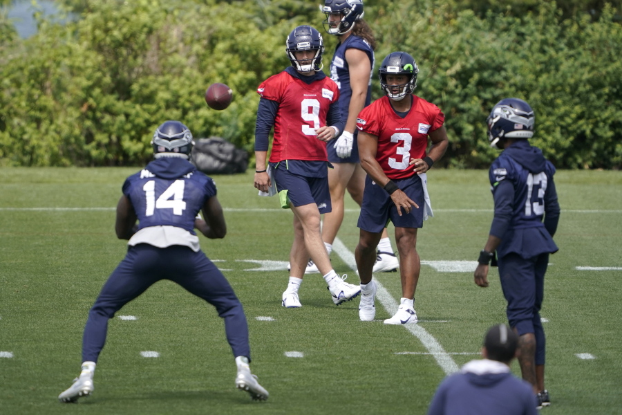 Seattle Seahawks quarterback Russell Wilson (3) passes to wide receiver DK Metcalf (14) during NFL football practice Tuesday, June 8, 2021, in Renton, as quarterback Danny Etling (9) and wide receiver Darvin Kidsy (23) look on. (AP Photo/Ted S.