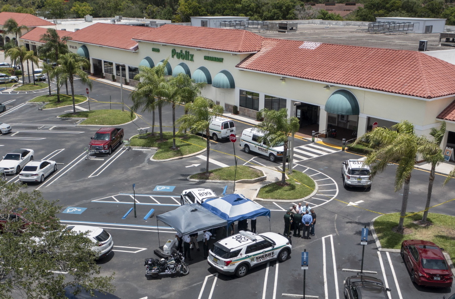Police gather at the Publix shopping center at the scene of a shooting in Royal Palm Beach, Fla., on Thursday, June 10, 2021.  Authorities say a shooting inside a Florida supermarket has left three people dead, including the shooter.