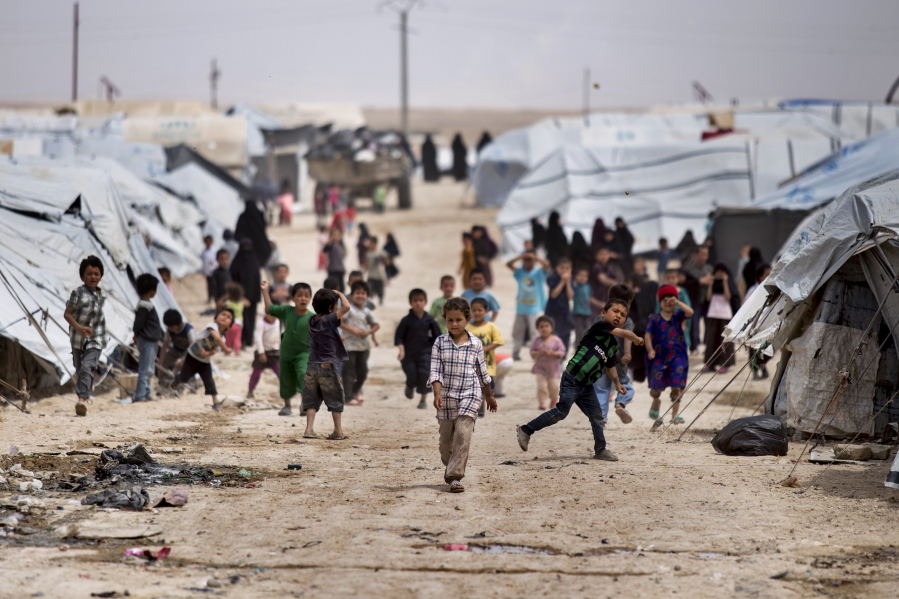 Children gather outside their tents, at al-Hol camp, which houses families of members of the Islamic State group, in Hasakeh province, Syria, Saturday, May 1, 2021.  It has been more than two years that some 27,000 children have been left to languish in al-Hol camp, which houses families of IS members.   Most of them not yet teenagers, they are spending their childhood in a limbo of miserable conditions with no schools, no place to play or develop and seemingly no international interest in resolving their situation.