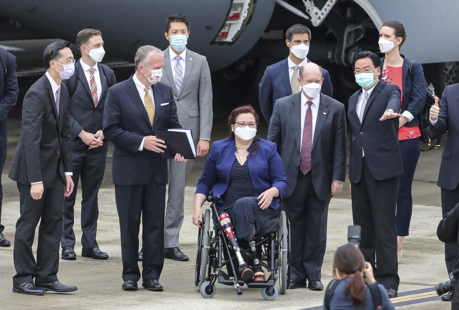 Taiwan's Foreign Minister Joseph Wu, second right, gestures as he welcomes U.S. senators to his right Democratic Sen. Christopher Coons of Delaware, a member of the Foreign Relations Committee, Democratic Sen. Tammy Duckworth of Illinois and Republican Sen. Dan Sullivan of Alaska, members of the Armed Services Committee on their arrival at the Songshan Airport in Taipei, Taiwan on Sunday, June 6, 2021. The three U.S. senators arrived in Taiwan to meet with senior government officials and discuss U.S.-Taiwan relations and other issues in a trip that is likely to anger China, which claims Taiwan as its territory and objects to Taiwan being called a country.