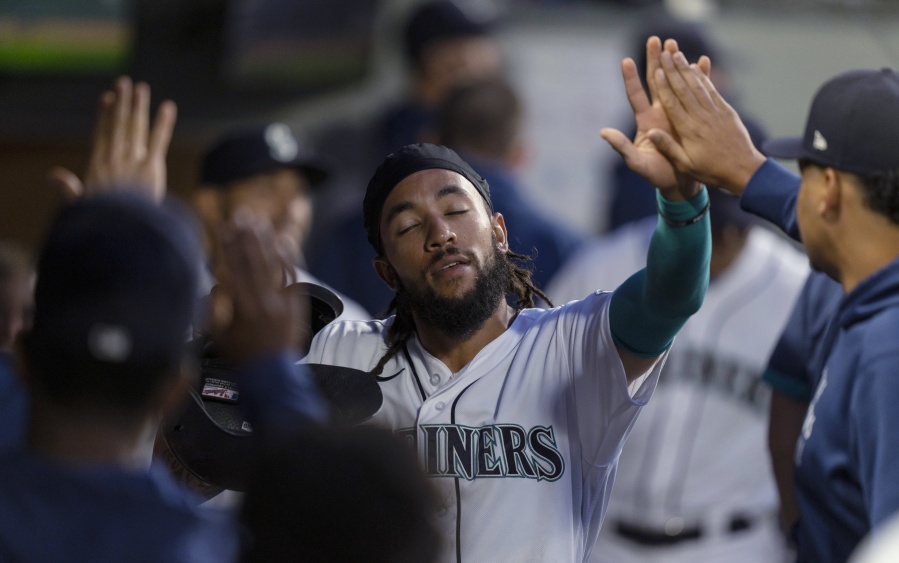 Seattle Mariners' J.P. Crawford celebrates in the dugout after scoring against the Minnesota Twins during the sixth inning of a baseball game Tuesday, June 15, 2021, in Seattle.