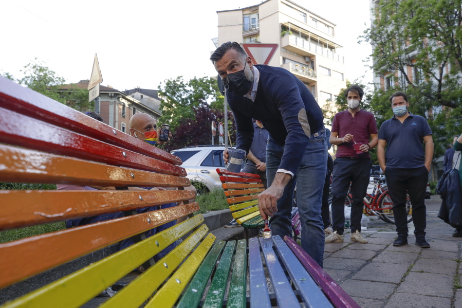FILE - In this Friday, May 7, 2021 filer, Italian lawmaker Alessandro Zan paints a bench in the colors of the rainbow, in Milan, Italy. The Vatican has formally opposed proposed Italian legislation that seeks expand anti-discrimination protections to people who are gay and transgender, along with women and people with disabilities, the leading Italian daily Corriere della Sera reported on Tuesday. Activists immediately denounced Vatican meddling in the Italian legislative process as "unprecedented. Italian politicians and activist groups reacted strongly to what they see as an attempt to derail the so-called Zan Law, named for a Democratic Party lawmaker and gay rights activist Alessandro Zan.