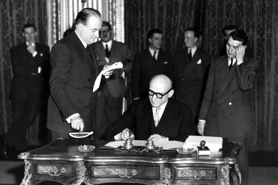 FILE - In this April 18, 1950 file photo, French Foreign Minister Robert Schuman signs a treaty. Pope Francis has put one of the architects of the plan for European integration, a forerunner of the European Union, on the path to possible sainthood. The Vatican said on Saturday, June 19, 2021 that the pontiff authorized a decree declaring the "heroic virtues" of Robert Schuman, a former French minister and Resistance fighter in World War II, who died in 1963 and who had been president of the European Parliament from 1958 till 1960.