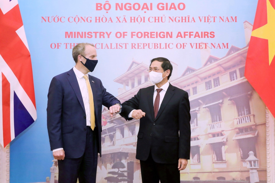 Britain's Foreign Secretary Dominic Raab, left, and Vietnamese Foreign Minister Bui Thanh Son greet with an elbow bump in Hanoi, Vietnam, Tuesday, Jun. 22, 2021. The Britain's top diplomat is on a three-nation visit in Southeast Asia to promote closer ties and trade with the region following the U.K.'s exit from the European Union.