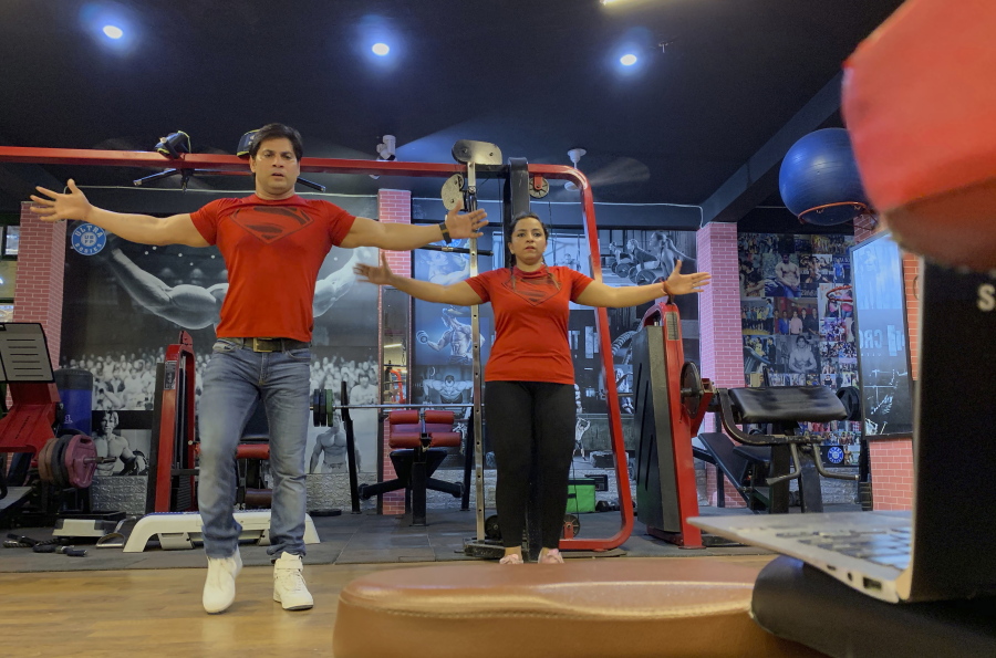 Bijender and Kanika Gautam, owners of the Ultra Bodies Fitness Studio, take online class from their closed Gyms on the outskirts of New Delhi, India, Thursday, June 10, 2021. Gyms were among the last types of venues allowed to reopen from the 2020 lockdown and they were closed again during the latest outbreaks. The Gautams had been thriving on income from their 100 gym members, making enough to rent their two-story space and pay five trainers. Now, they're relying on whatever they can scrape together from offering online fitness training, and struggling to afford rent and school fees for their two children. (AP Photo/Rishabh R.