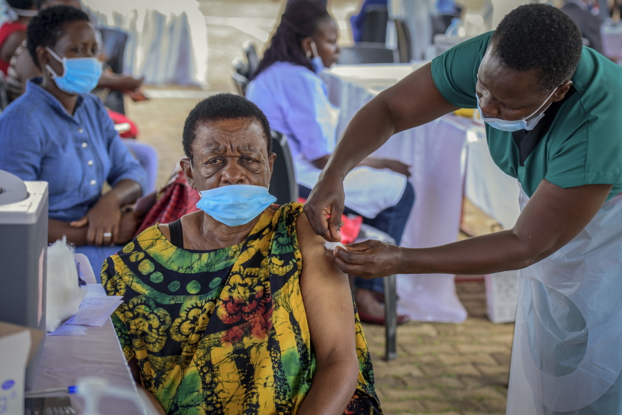 A woman receives a coronavirus vaccination at the Kololo airstrip in Kampala, Uganda, Monday, May 31, 2021. Africa is especially vulnerable. As virus cases surge in the world's poorest countries, a sense of dread is growing among millions of the unvaccinated, especially those who toil in the informal, off-the-books economy, live hand-to-mouth and pay cash in health emergencies.