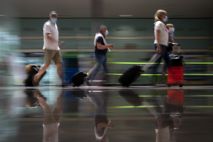 Tourists arrive at Barcelona airport, Spain, Monday, June 7, 2021. Spain is trying to ramp up its tourism industry by welcoming from Monday vaccinated visitors from most countries, as well as all Europeans who prove that they are not infected with the coronavirus.