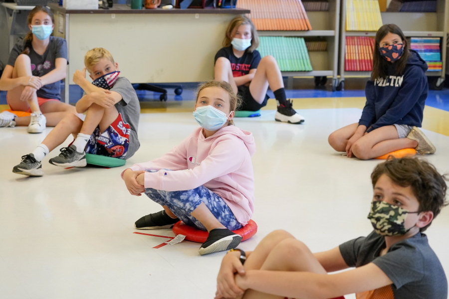 FILE - In this May 18, 2021 file photo, fifth graders wearing face masks are seated at proper social distancing during a music class at the Milton Elementary School in Rye, N.Y. As the nation closes out a school year marred by the pandemic, some states are now starting to release new standardized test scores that offer an early glimpse at just how far students have fallen behind -- with some states reporting that the turbulent year has reversed years of progress across every academic subject. New York, Georgia and some other states pushed to cancel testing for a second year so schools could focus on classroom learning.