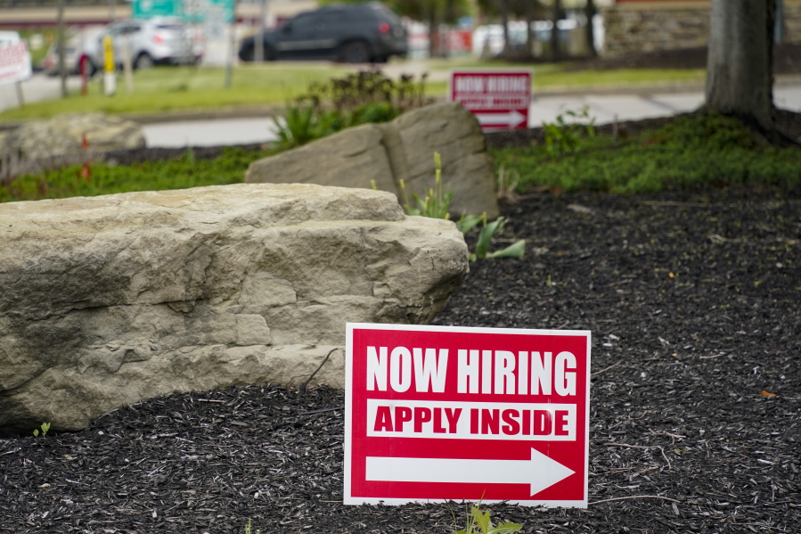 This May 5, 2021 photo shows hiring signs posted outside a gas station in Cranberry Township, Butler County, Pa. The number of Americans applying for unemployment benefits dropped last week,  reported Thursday, June 24, a sign that layoffs declined and the job market is improving.