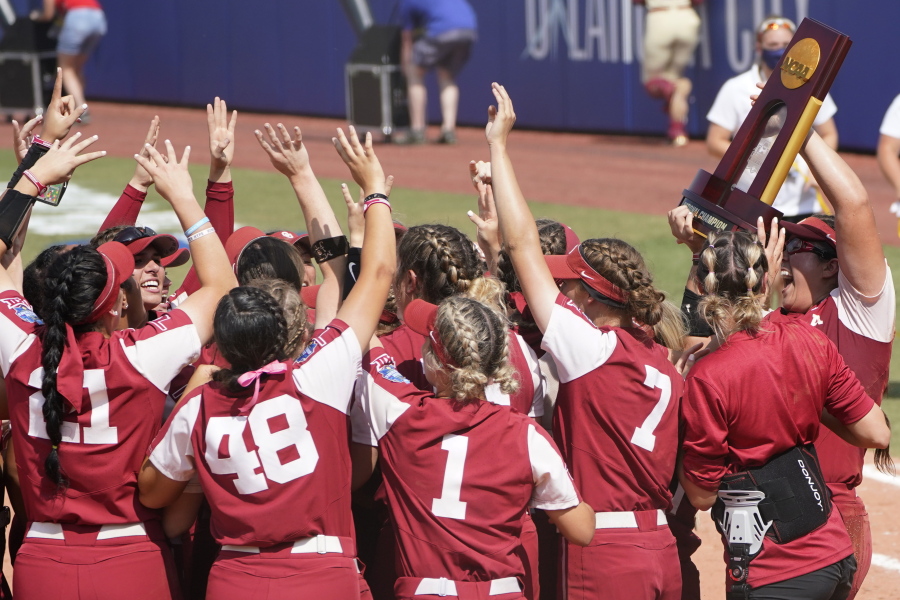 Oklahoma players celebrate with the trophy after defeating Florida State in the final game of the NCAA Women's College World Series softball championship series Thursday, June 10, 2021, in Oklahoma City.