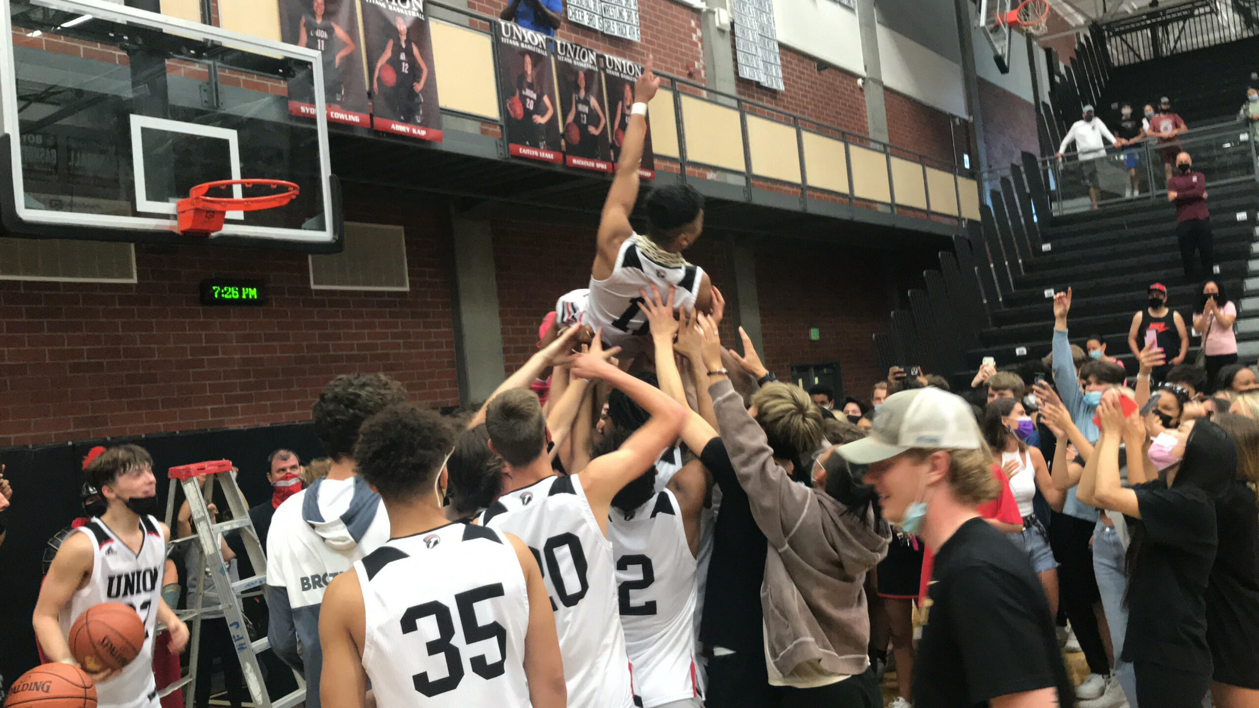 Union High School players and fans hoist Izaiah Vongnath after Vongnath cut down the net following Union's 61-60 victory over Skyview in Friday's 4A/3A GSHL district championship in boys basketball.