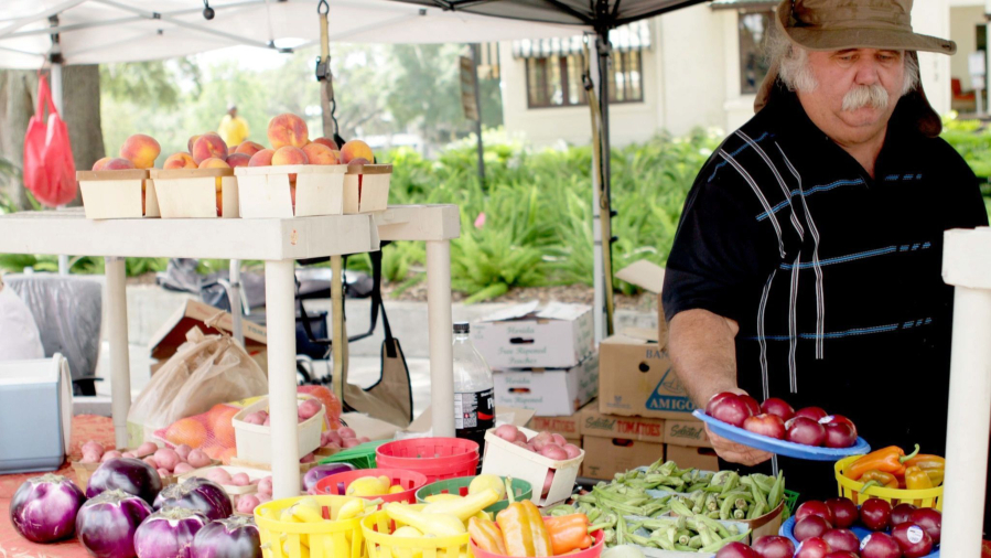 A customer checks out produce at a farmers market. Since the pandemic, farmers in Ohio are looking  for new ways to sell their meat and produce.